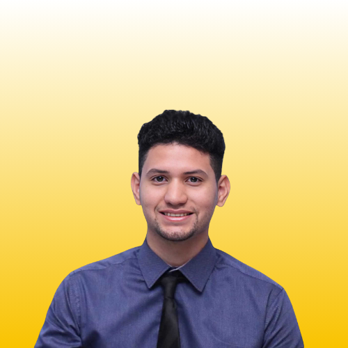 Smiling young man wearing a blue shirt and black tie, standing confidently on a bright yellow gradient background.