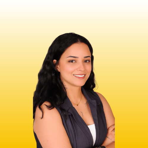 Smiling brunette woman in sleeveless top and necklace posing against a warm yellow gradient background full headshot
