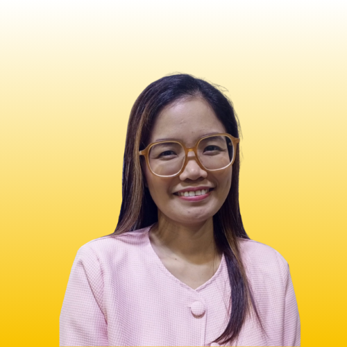 Smiling woman with glasses and long dark hair wearing pink top against a bright yellow gradient background with sun
